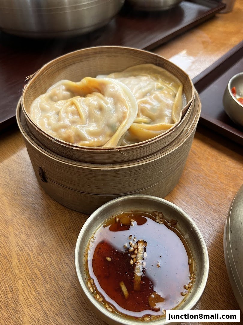 Steamed dumplings served in a bamboo steamer with a dipping sauce.