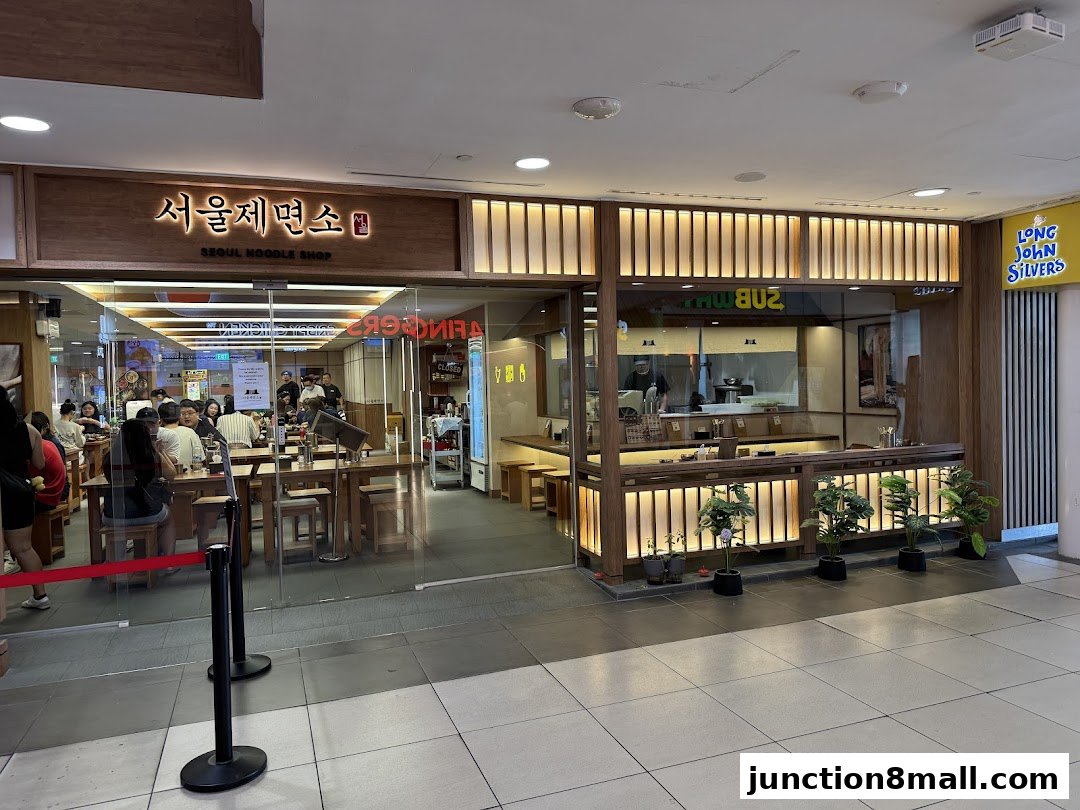 The entrance of Seoul Noodle Shop, with customers seated inside and a Subway restaurant next door.