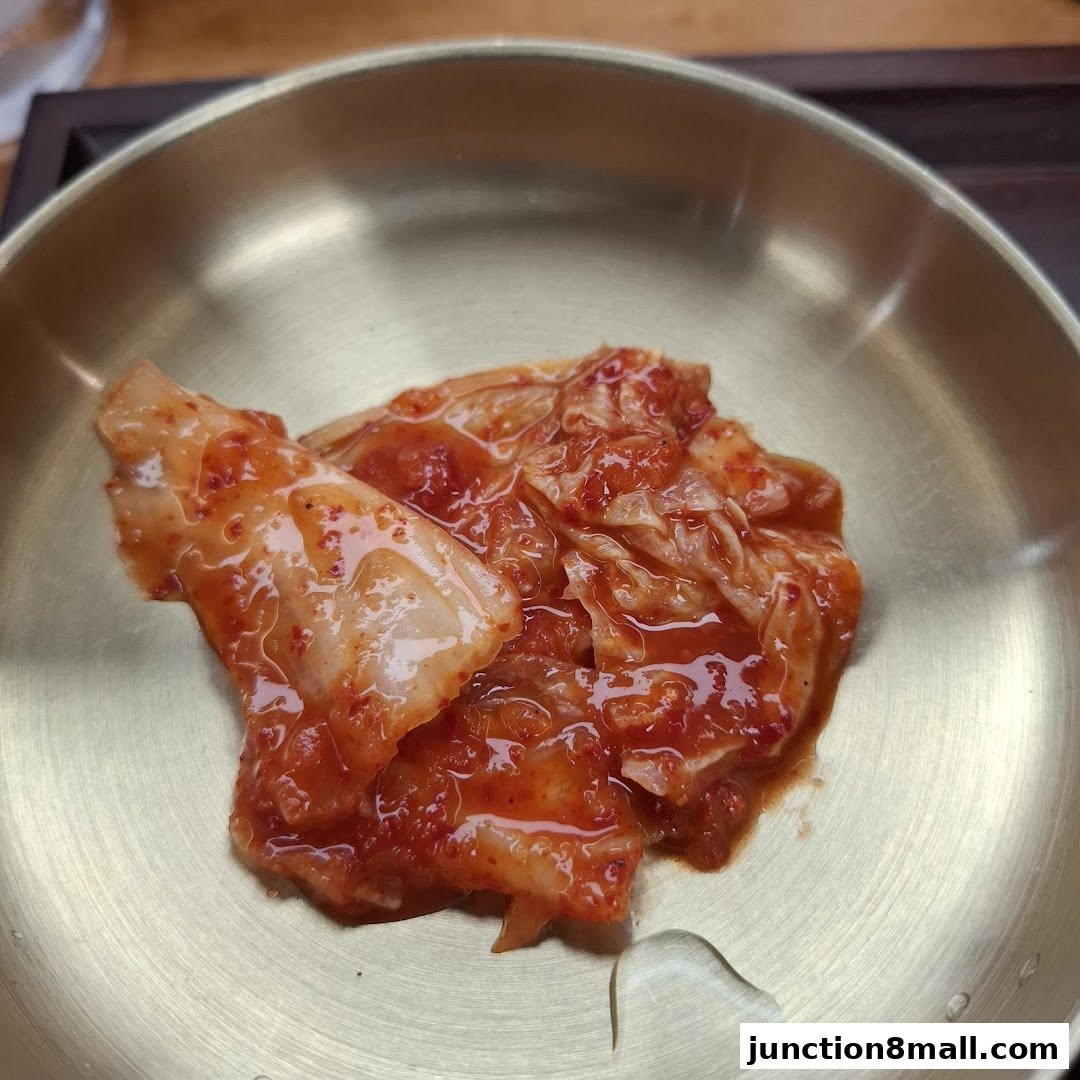 A close-up shot of kimchi served in a traditional brass bowl.