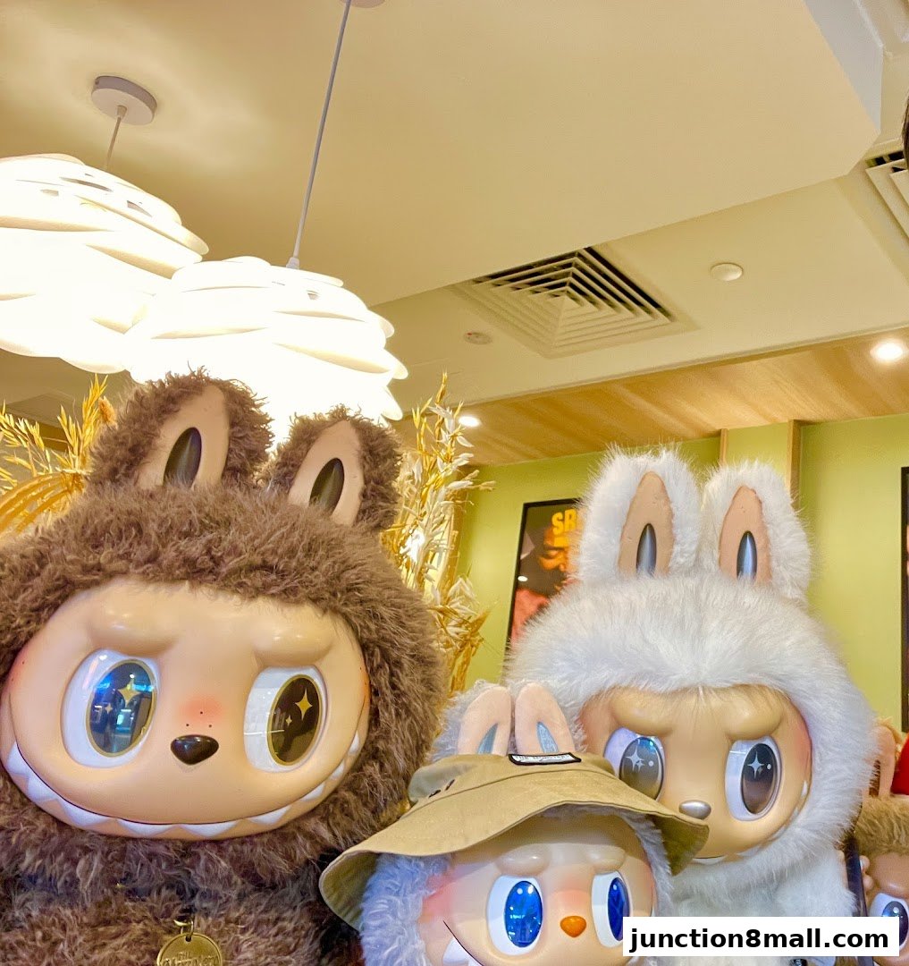 Three large, stylized character figures with big eyes and furry costumes are displayed indoors.