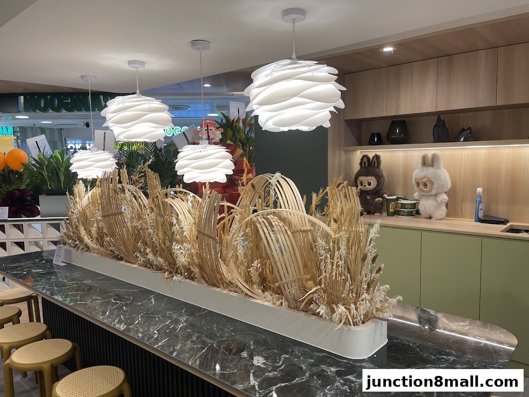 A modern dining area with a marble counter, decorative plants, and plush toys on shelves.