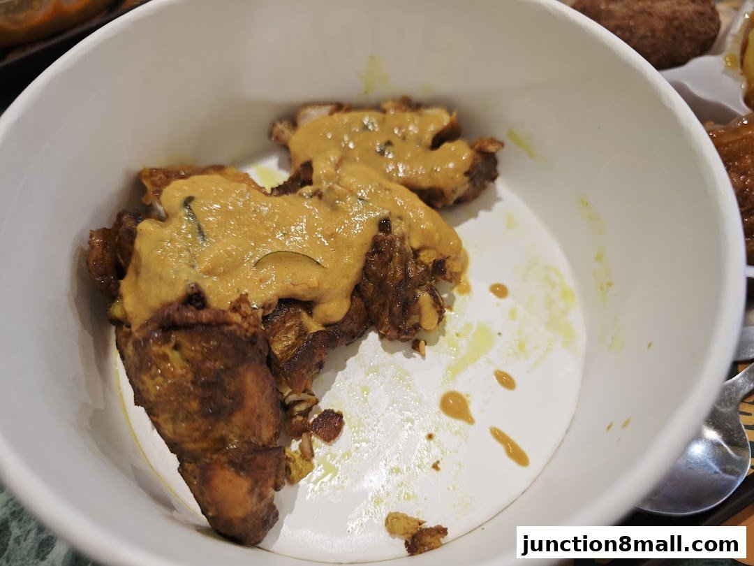 A close-up of a bowl of delicious curry chicken with a rich, savory sauce.