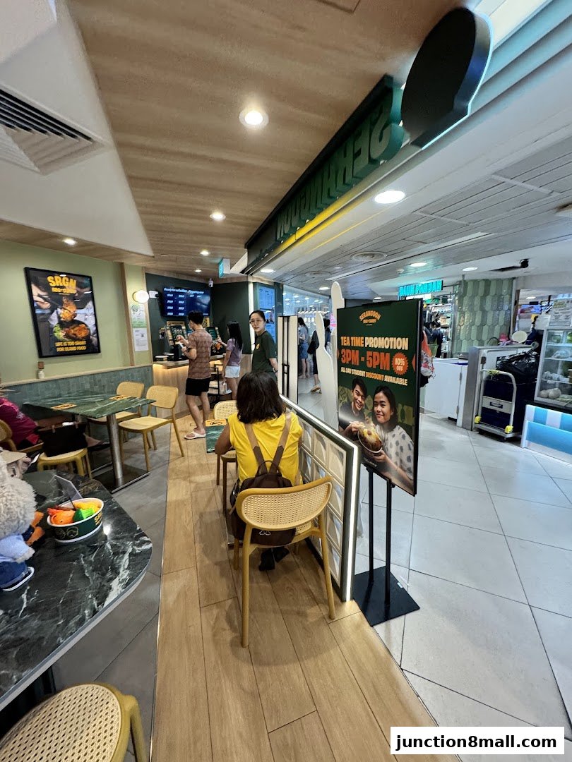 Customers seated at tables inside a casual dining restaurant with a promotional stand.