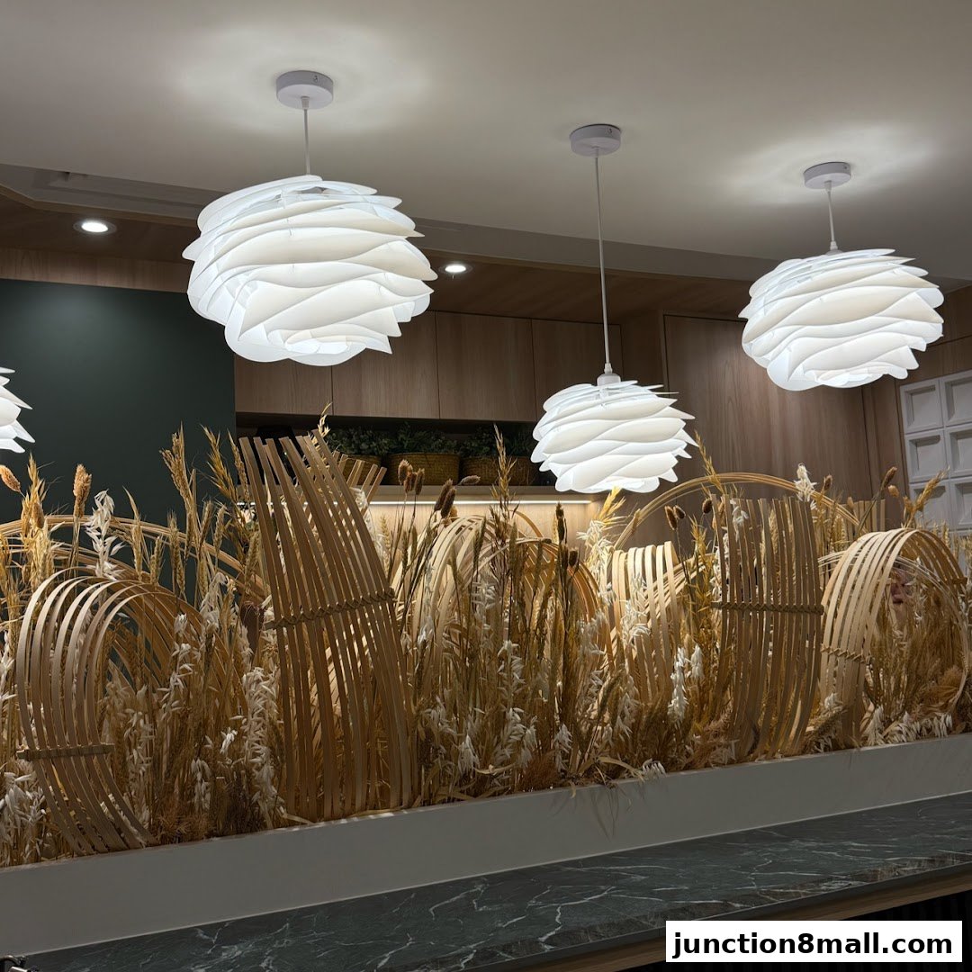 Interior shot of a restaurant with decorative dried plants and modern pendant lights.