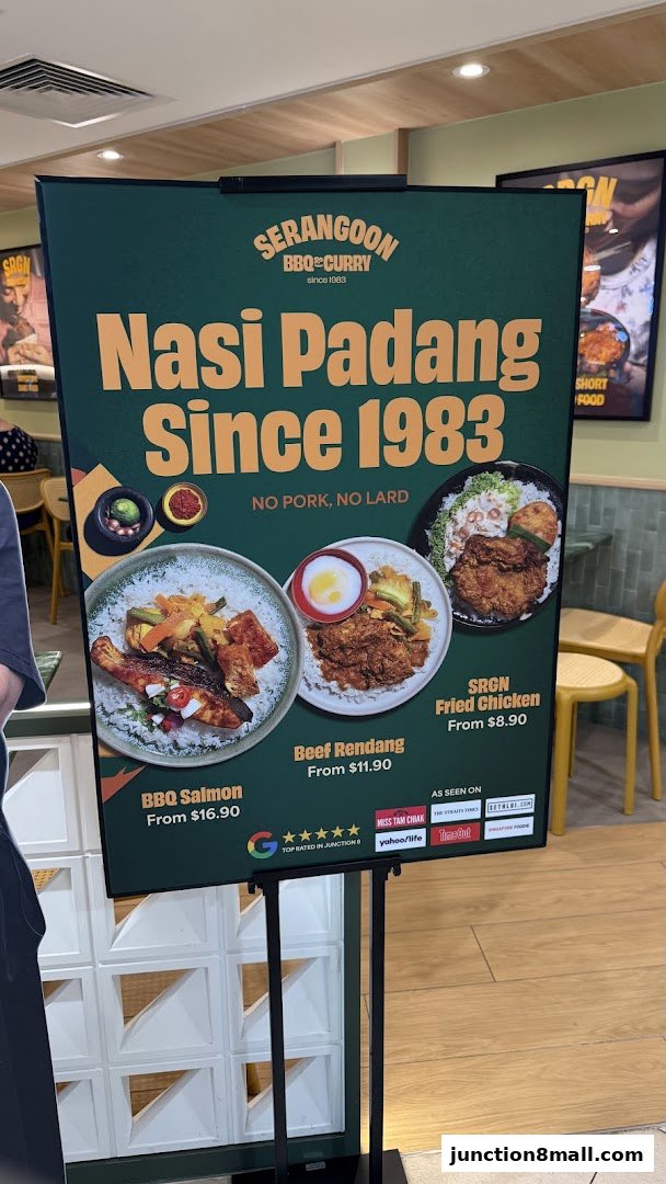 A sign advertising Serangoon BBQ & Curry's Nasi Padang dishes, featuring BBQ Salmon, Beef Rendang, and Fried Chicken.