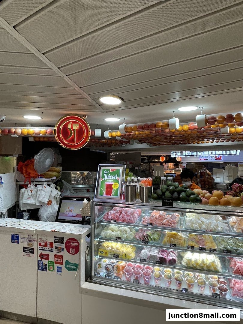 A display of fresh fruits and juices in a refrigerated case at SF Fruits Juices.