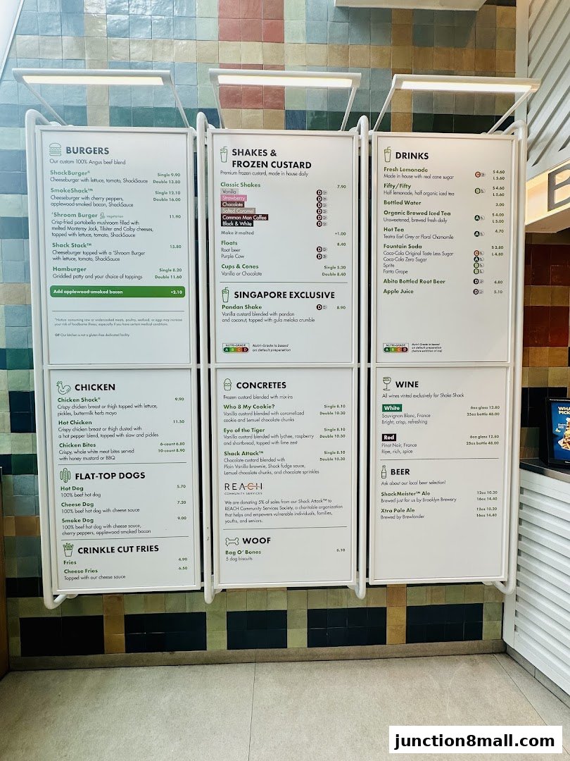 A menu board displaying various burgers, chicken items, hot dogs, fries, shakes, drinks, concretes, wine, and beer options.