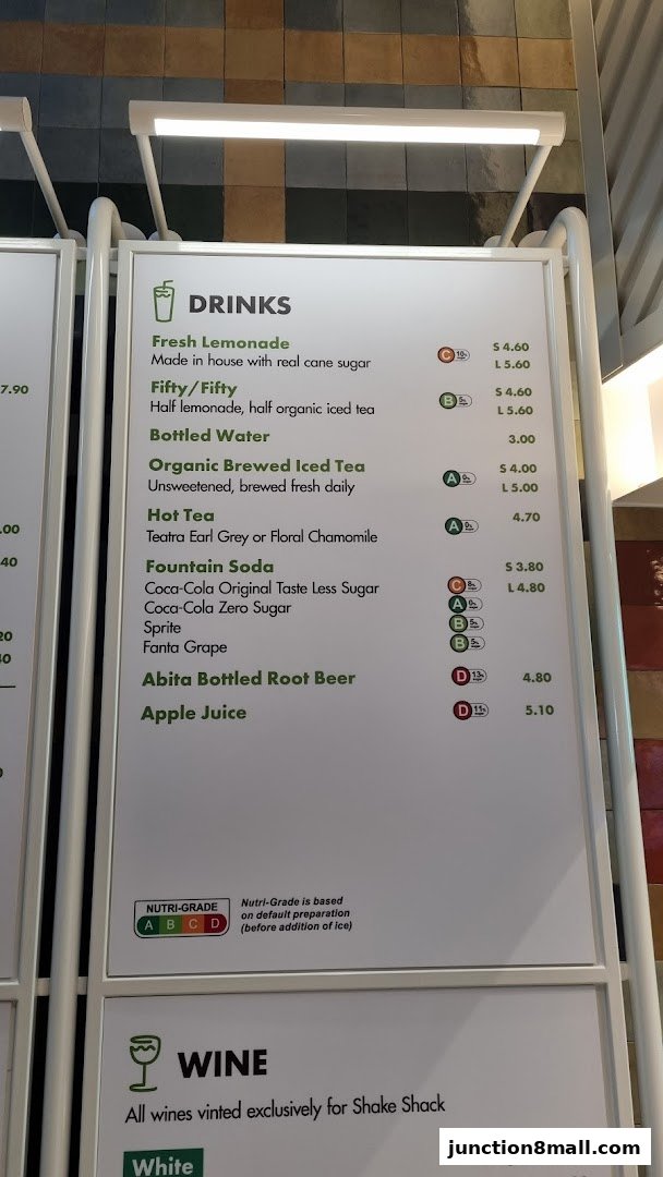 A menu board displaying drinks and wine options at Shake Shack Junction 8.
