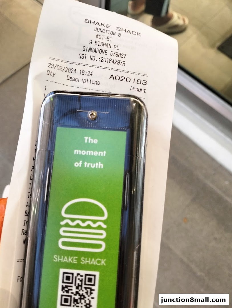 A receipt and a Shake Shack branded pager with a QR code.