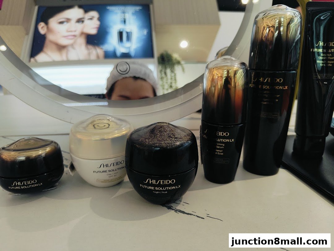 Shiseido Future Solution LX skincare products displayed with a mirror reflecting a model.
