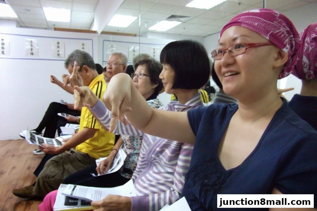 People attending a class or workshop, with hands raised and pointing.