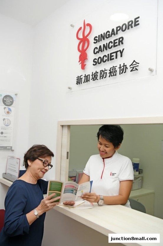 A patient consults with a staff member at the Singapore Cancer Society Clinic reception.