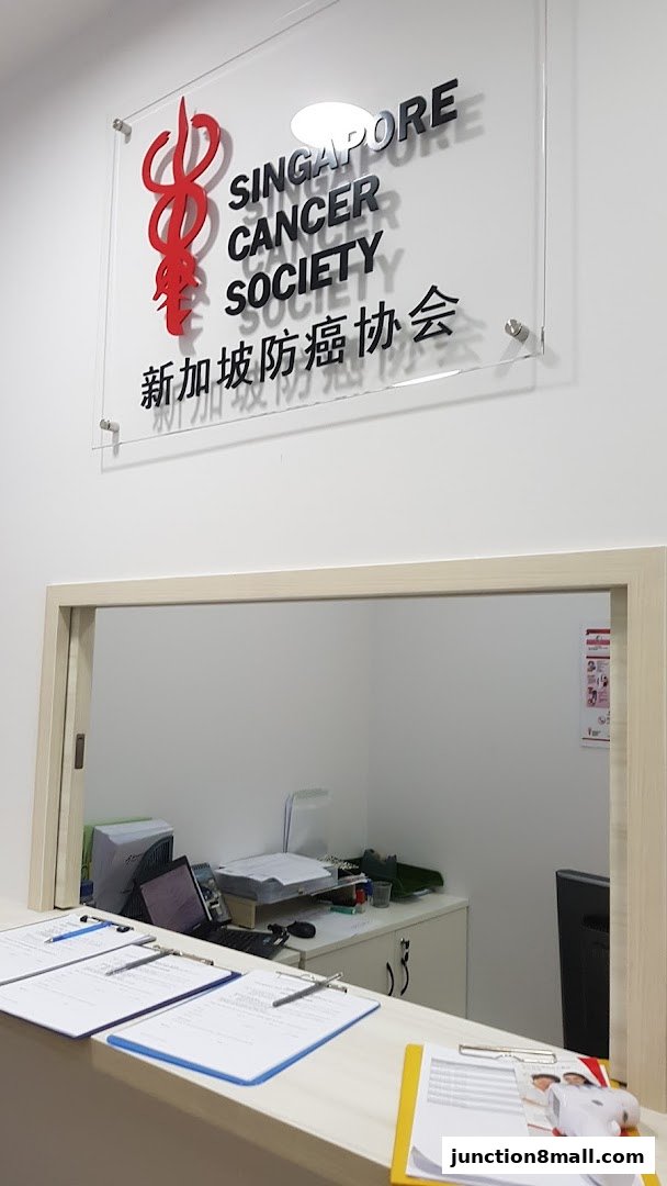 The reception area of Singapore Cancer Society Clinic Bishan with a prominent sign and a counter.