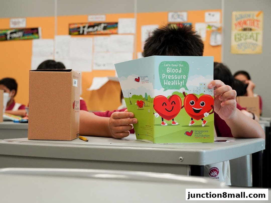 A child reads a brochure about keeping blood pressure healthy from the Singapore Heart Foundation.