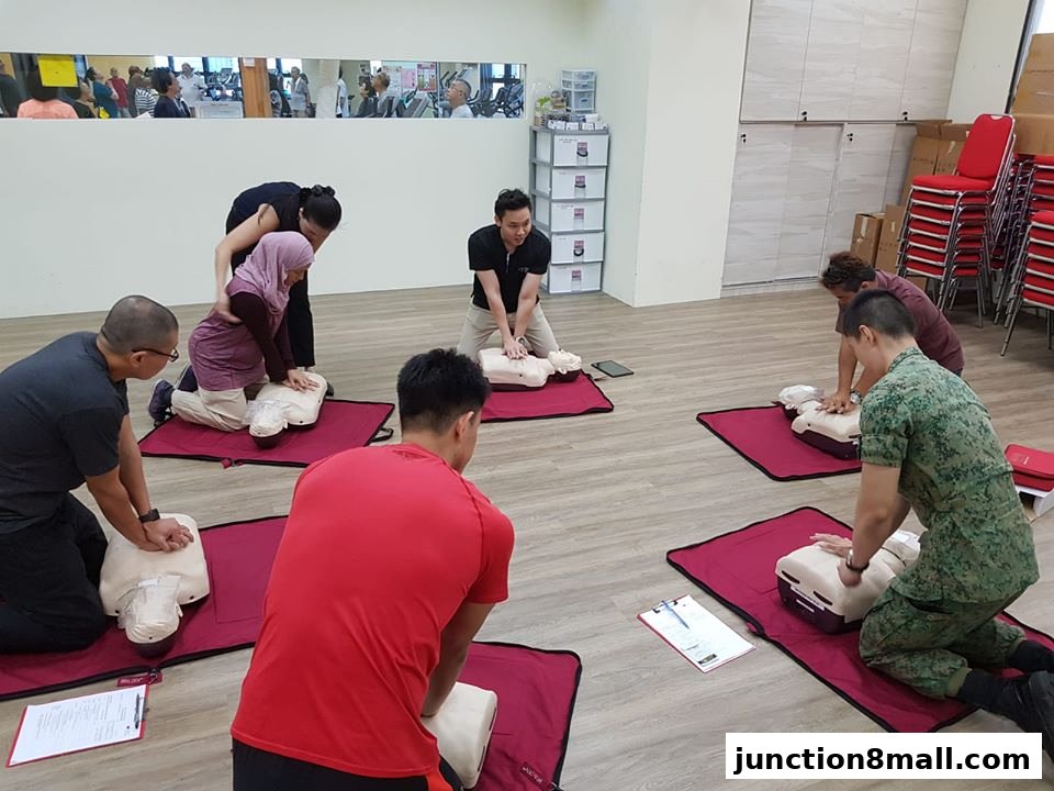 People practicing CPR on mannequins in a training session.