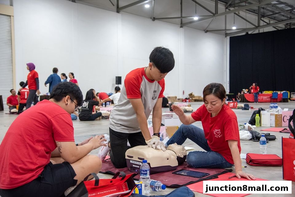 People practicing CPR on mannequins in a training session.