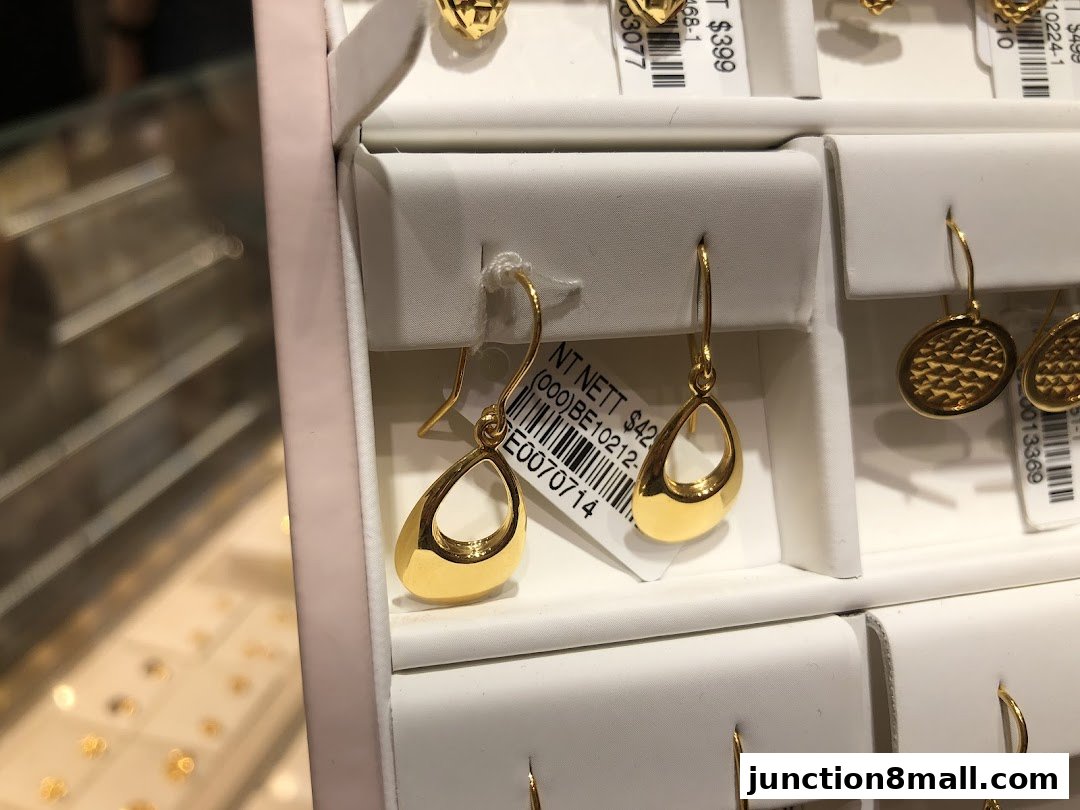Close-up of elegant gold drop earrings displayed in a jewelry store.