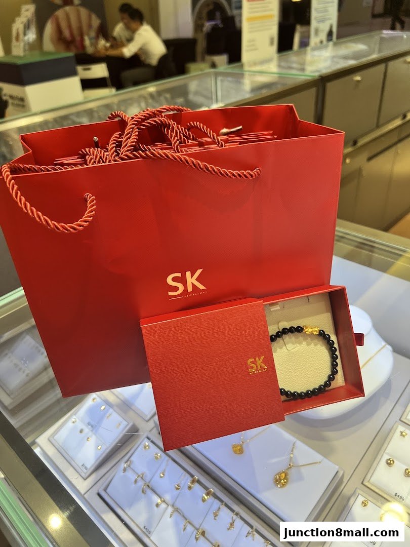 SK Jewellery shopping bag and gift box with a bracelet on display.