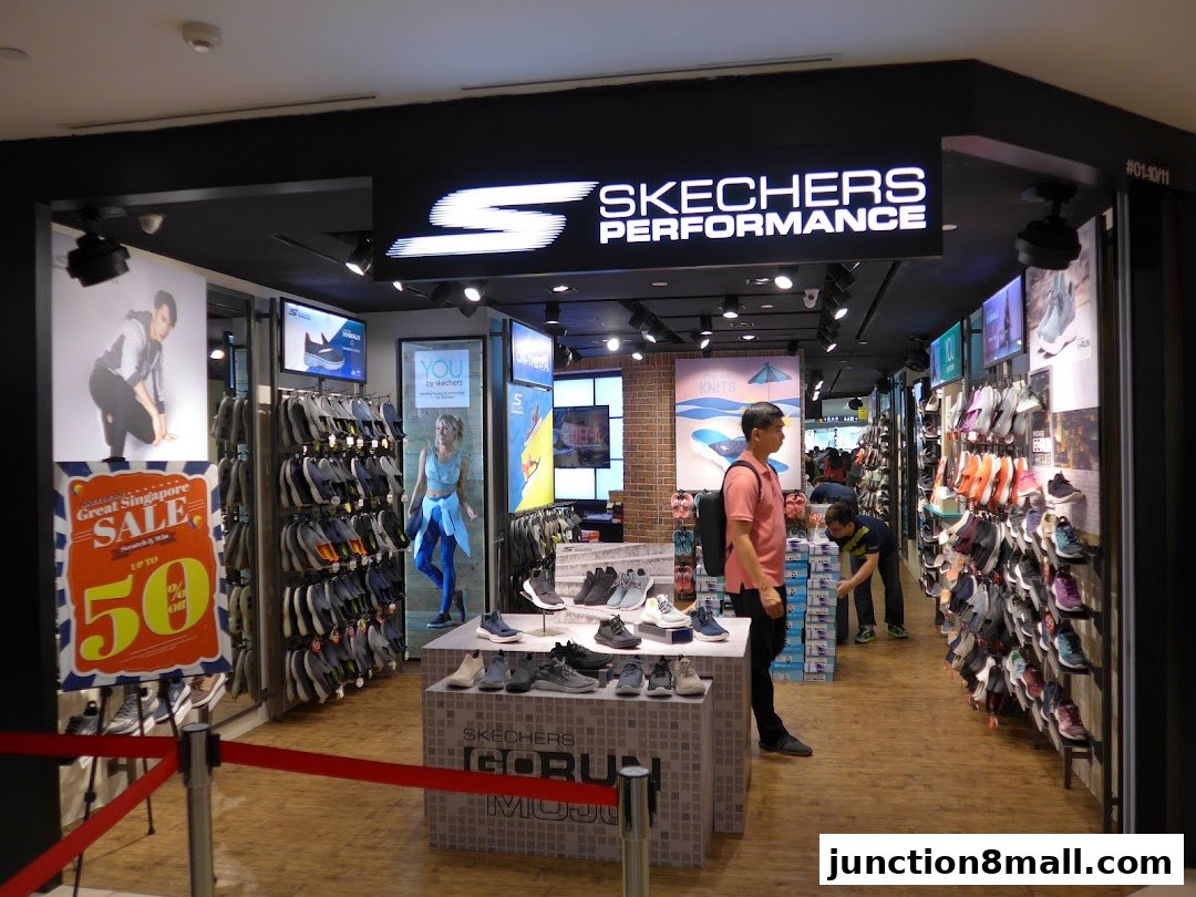 Interior view of a Skechers store showcasing a wide selection of athletic shoes and a sale promotion.