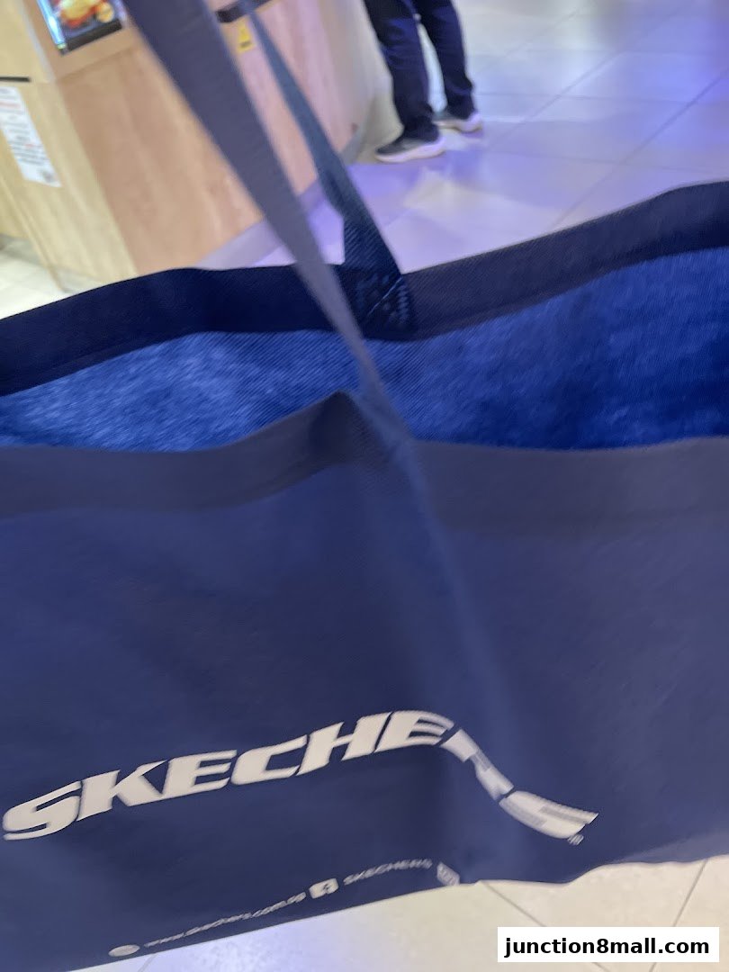A close-up of a blue Skechers shopping bag with the logo visible.