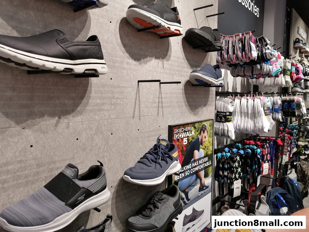 Skechers store interior displaying various shoes and socks on shelves and walls.