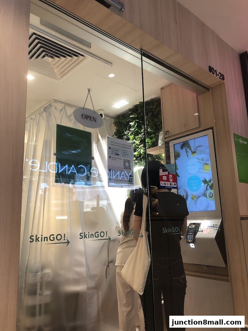 The entrance of a SkinGO! shop with an 'OPEN' sign and a digital display.