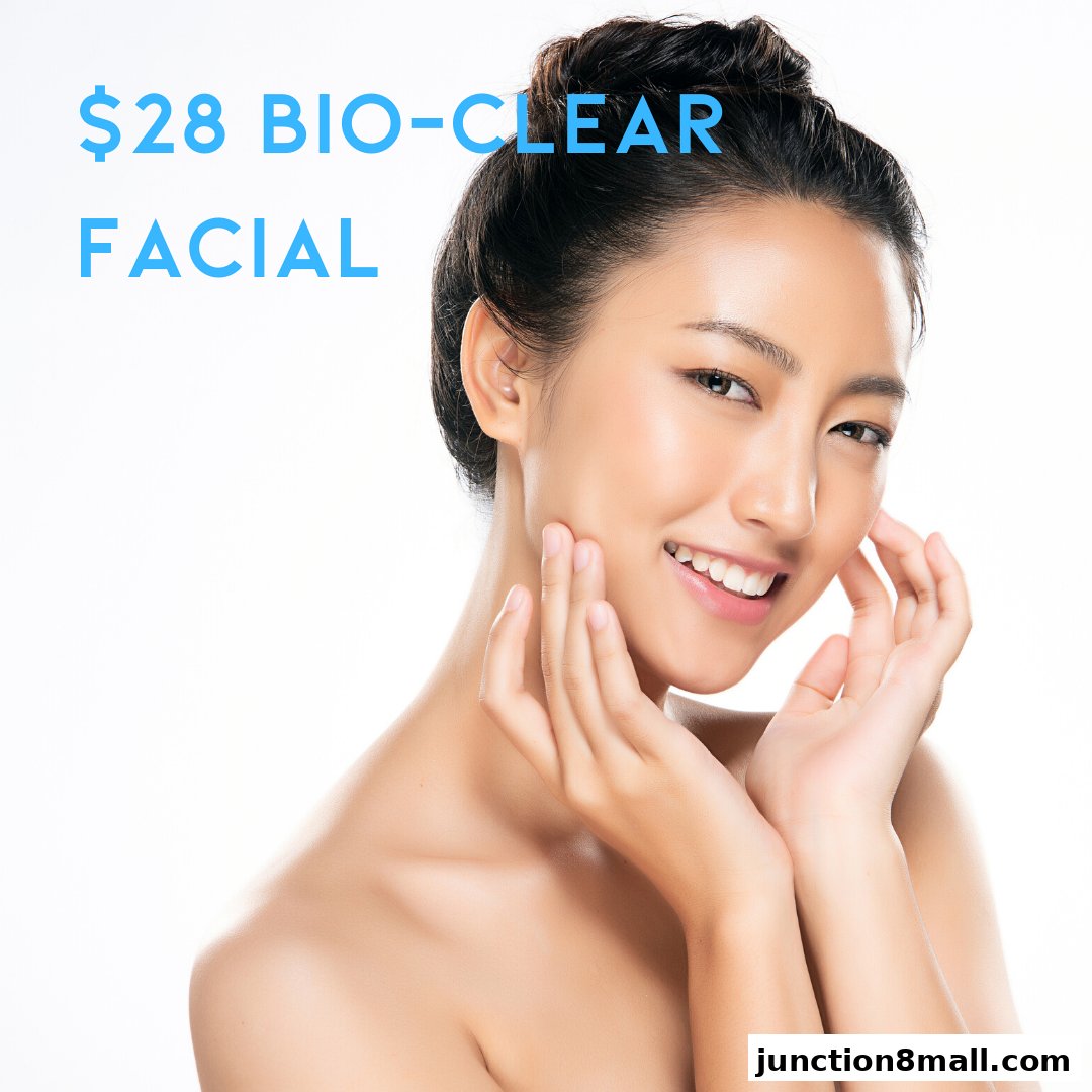 A smiling woman with clear skin touches her face, advertising a $28 Bio-Clear Facial.