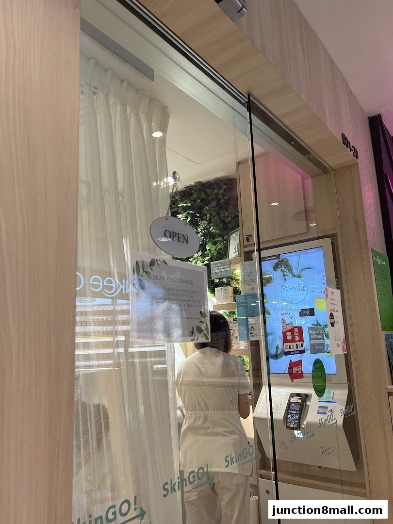 The entrance of a SkinGO! shop with an 'Open' sign and a digital display.