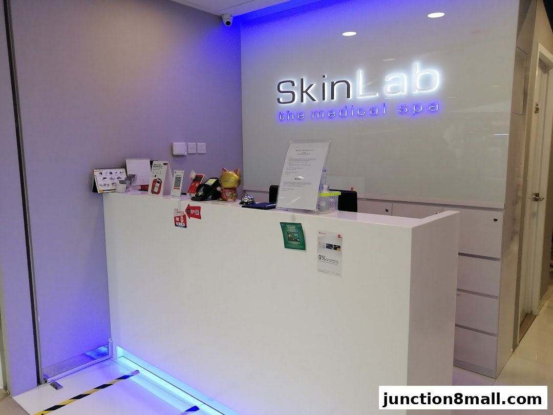 The reception counter of SkinLab The Medical Spa, featuring the brand's logo and various promotional materials.