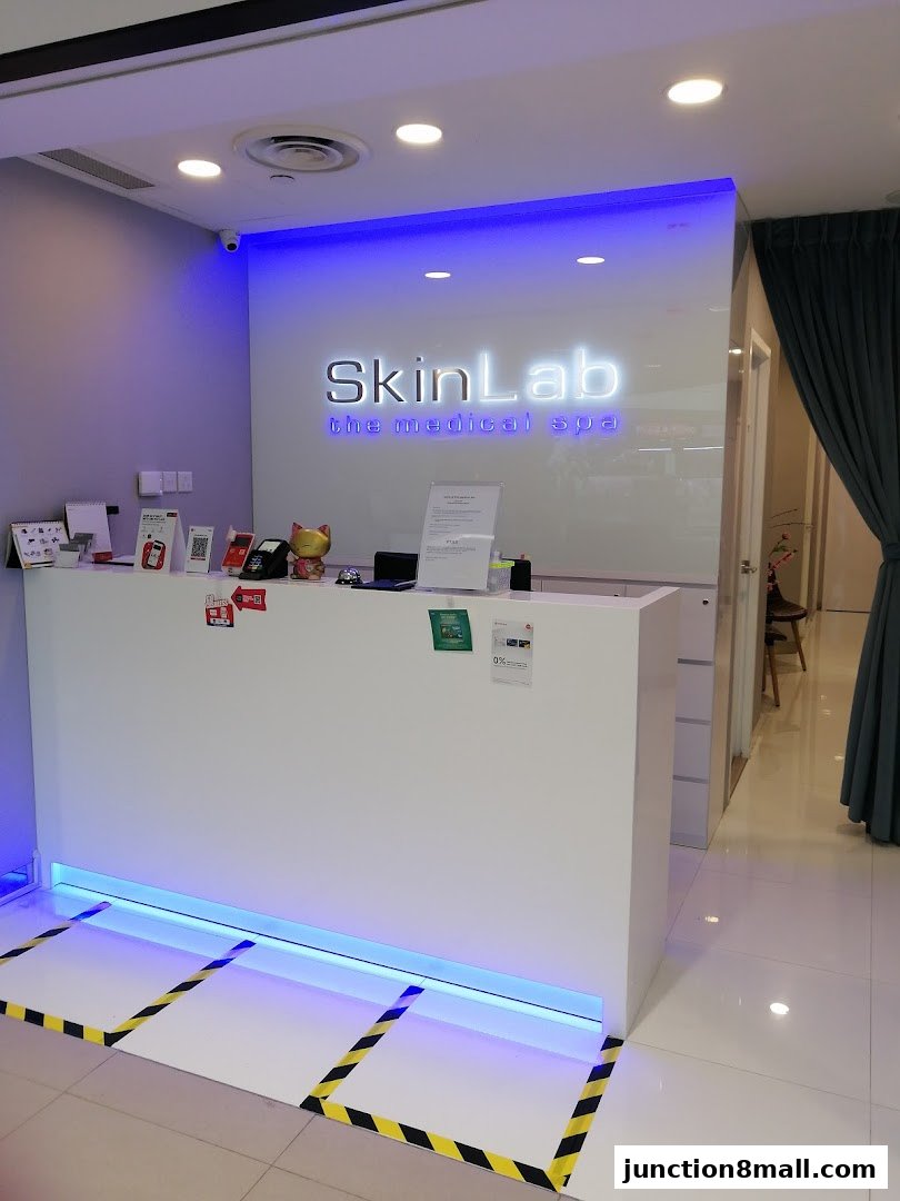 The reception area of SkinLab The Medical Spa, featuring a white counter and illuminated signage.