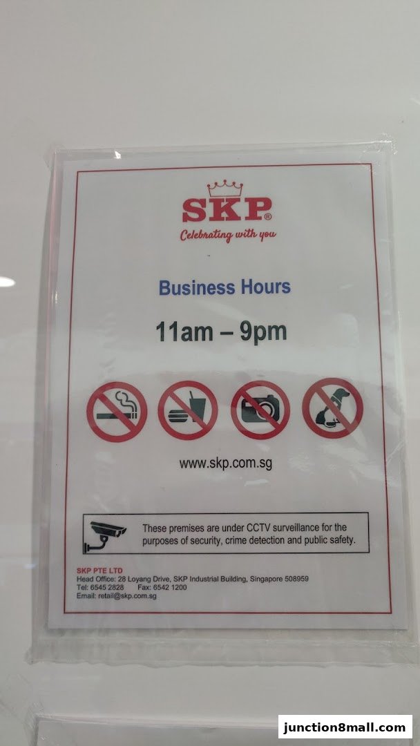 A sign displaying SKP's business hours, website, and contact information.