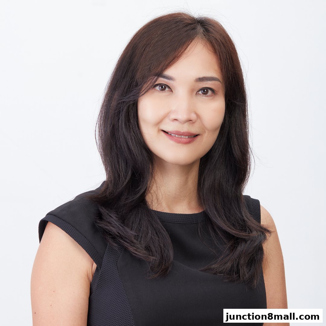 Portrait of a smiling woman with long, dark hair wearing a black dress.