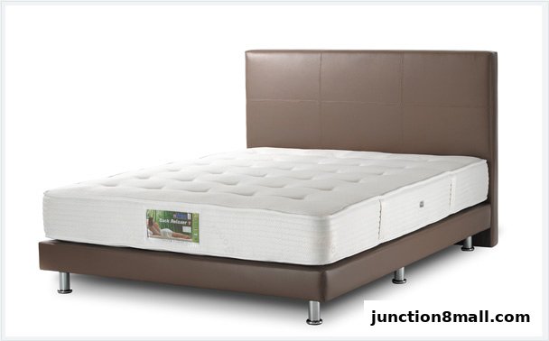 A white mattress with a brown headboard and base, featuring a label with a person relaxing.