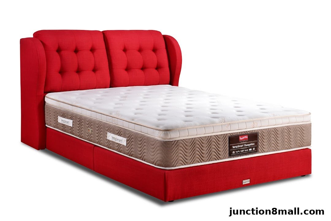 A red upholstered bed frame with a tufted headboard and a white mattress.