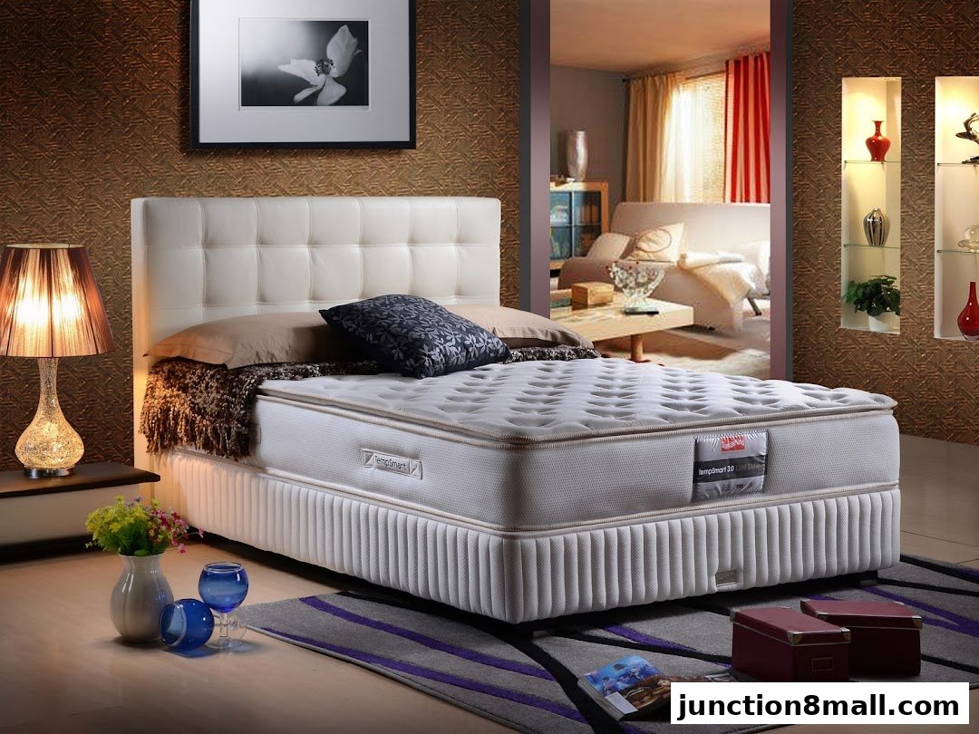 A luxurious bed with a white headboard and a comfortable mattress is displayed in a well-decorated room.