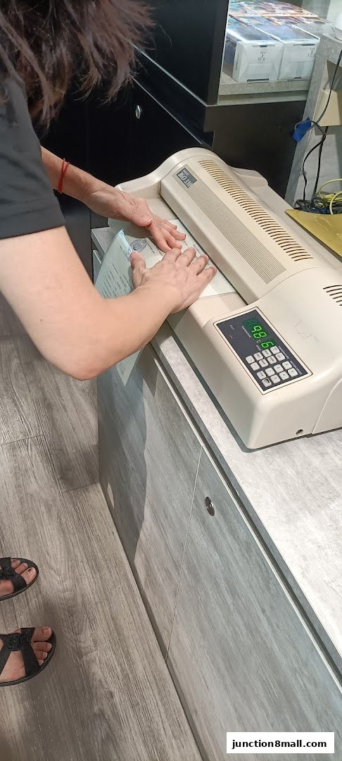 A person is using a laminating machine to protect a document.