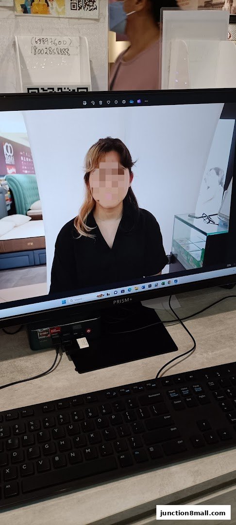 A computer screen displays a person's portrait with a blurred face, next to a display of beds.