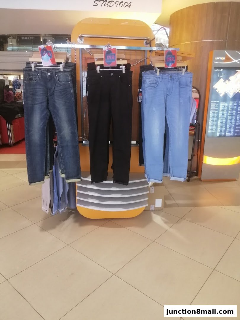 Studio04 shop displays jeans and shirts on a rack with price tags.