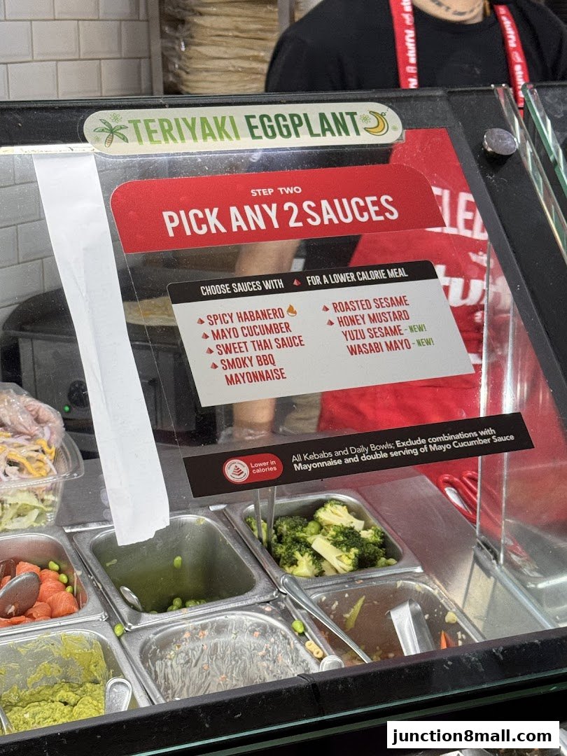 A display of food ingredients and sauce options at a restaurant counter.