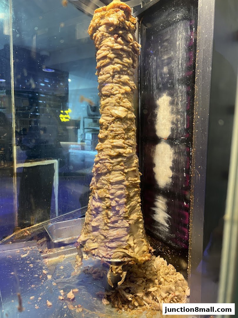 A vertical spit of seasoned meat slowly rotating, ready to be shaved for delicious meals.