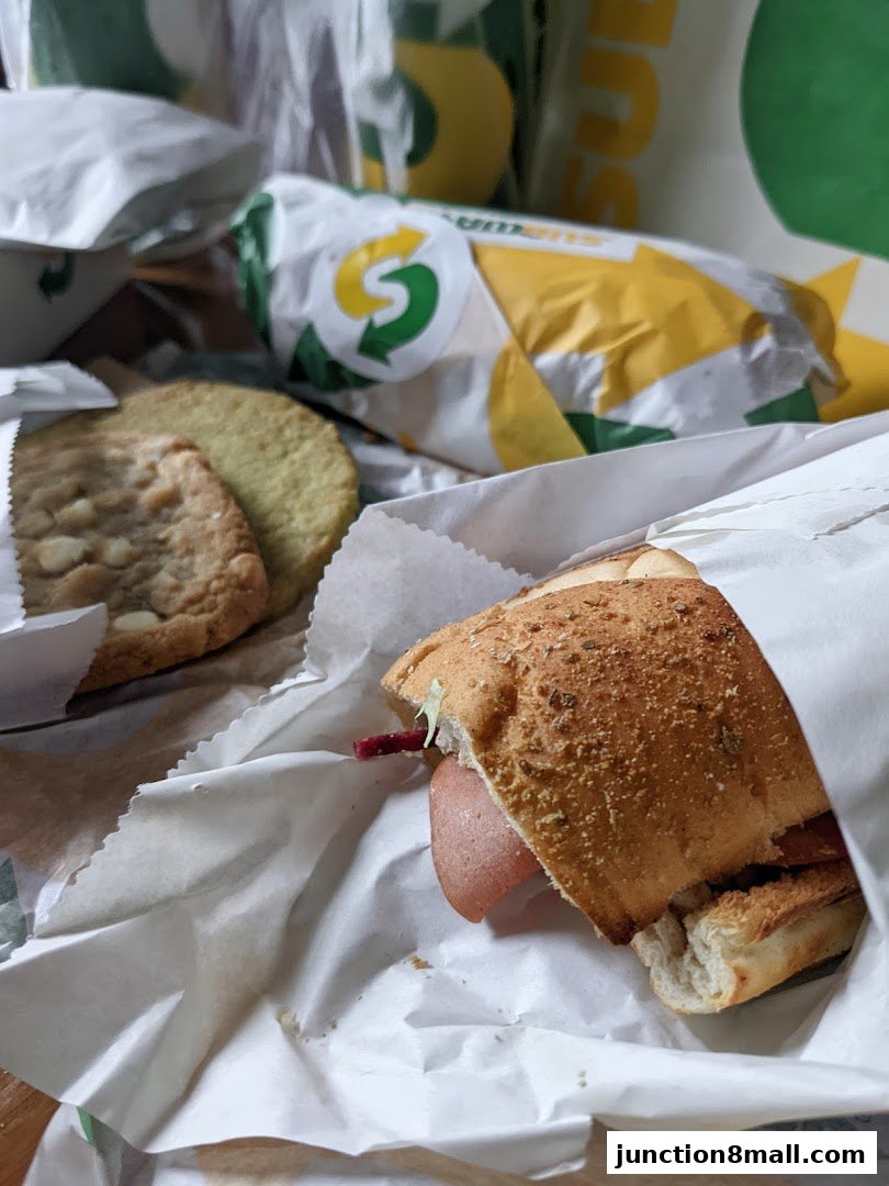 A Subway sandwich and cookies are displayed in their packaging.