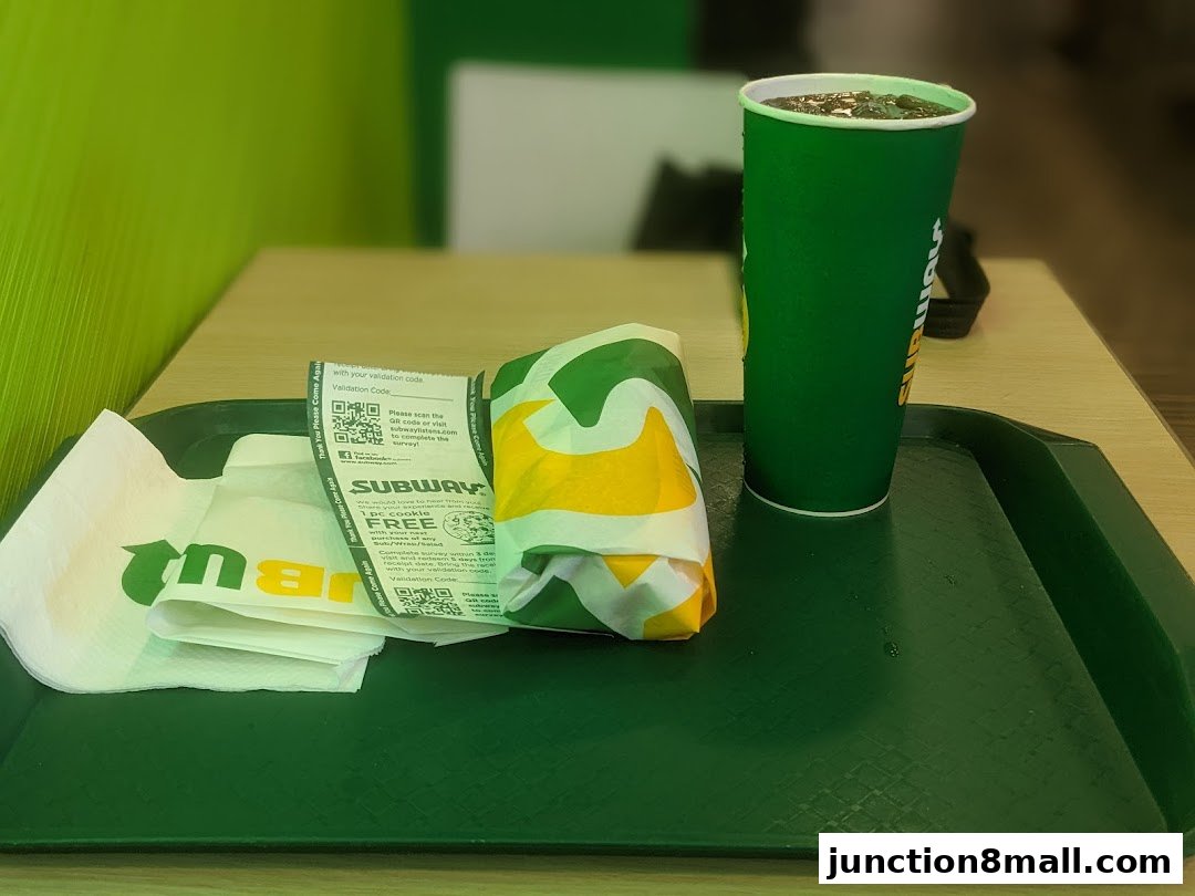 A Subway sandwich and drink on a tray with napkins and a survey receipt.
