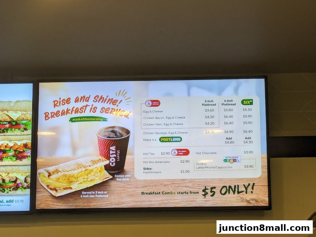 A digital menu board displaying breakfast options and prices for Subway.