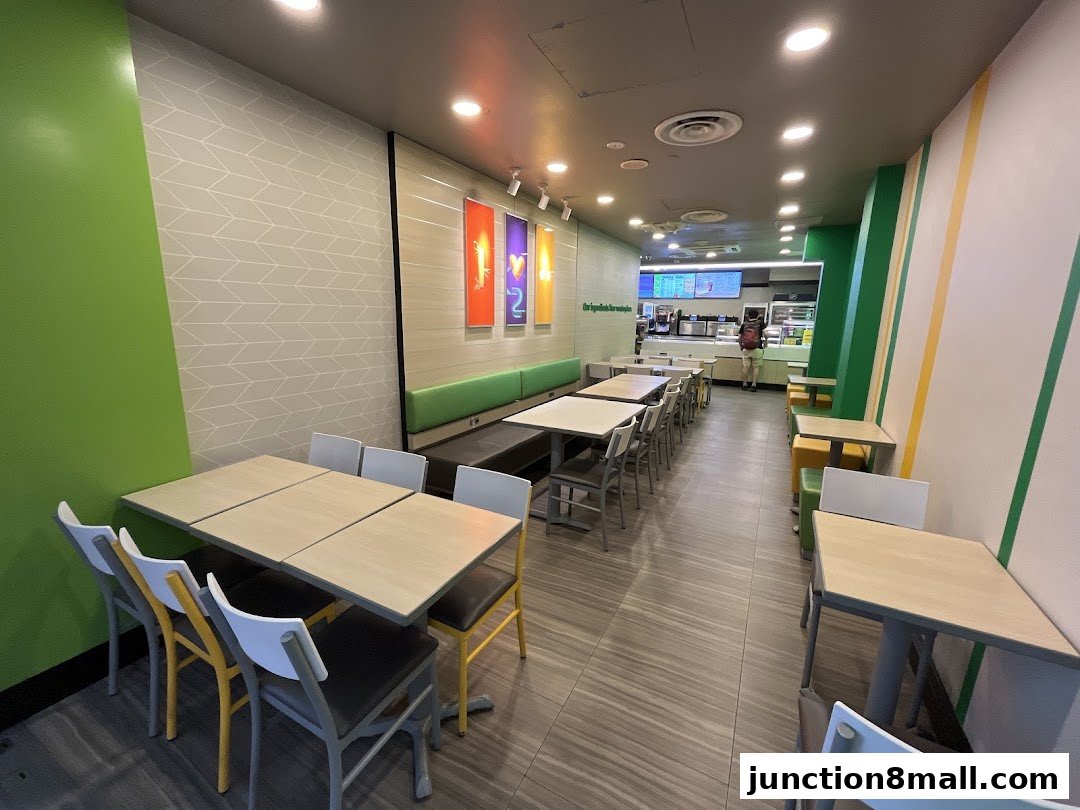 Interior view of a Subway restaurant with seating areas and a counter in the background.