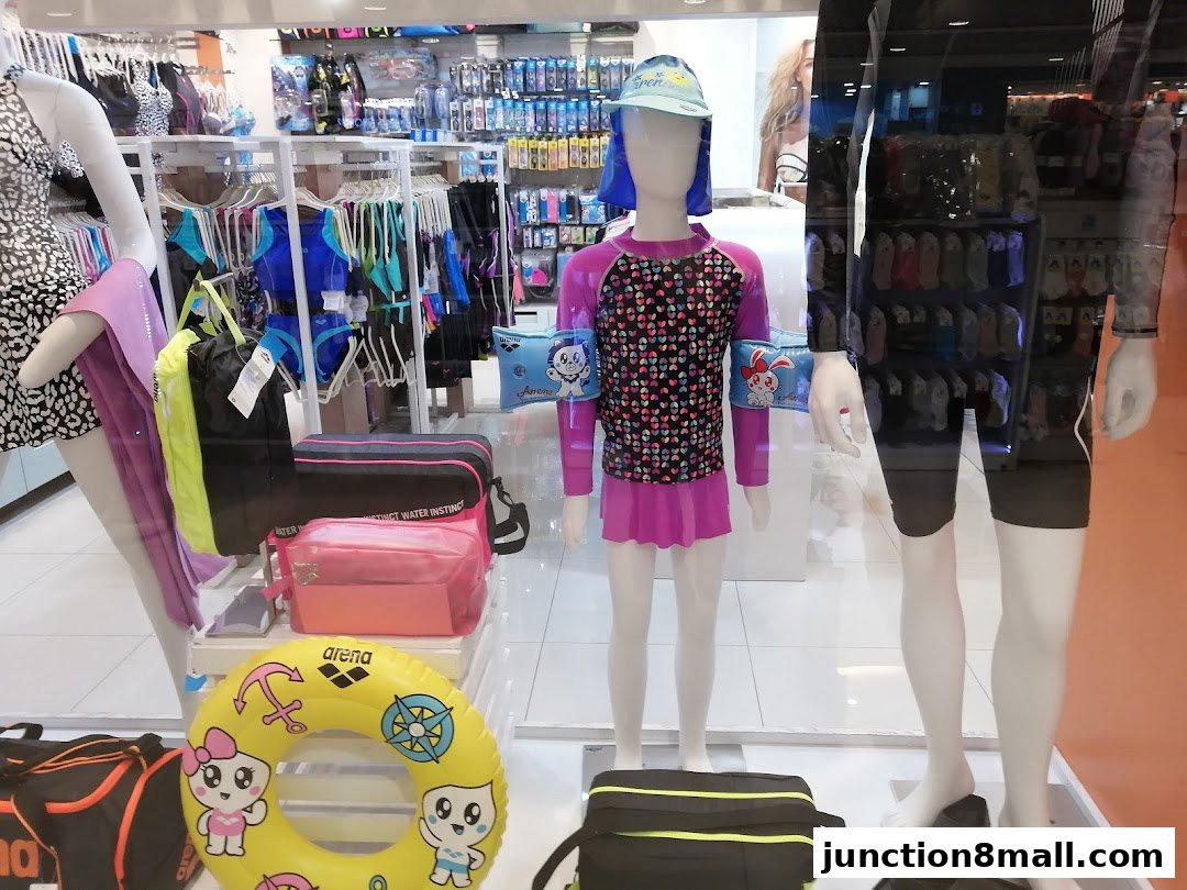 A shop window display featuring mannequins dressed in swimwear and accessories.