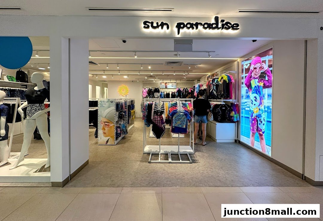 The entrance of Sun Paradise, a swimwear store, showcasing mannequins and racks of colorful swimwear.