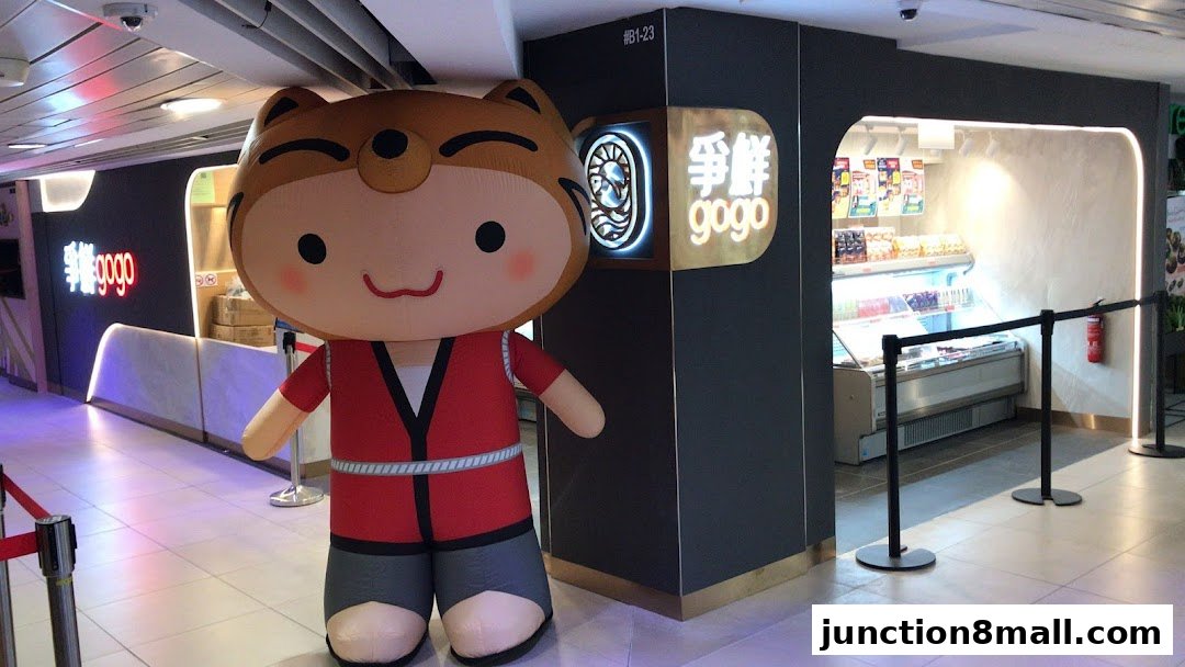 A large inflatable mascot stands in front of the Sushi Go Go shop entrance.
