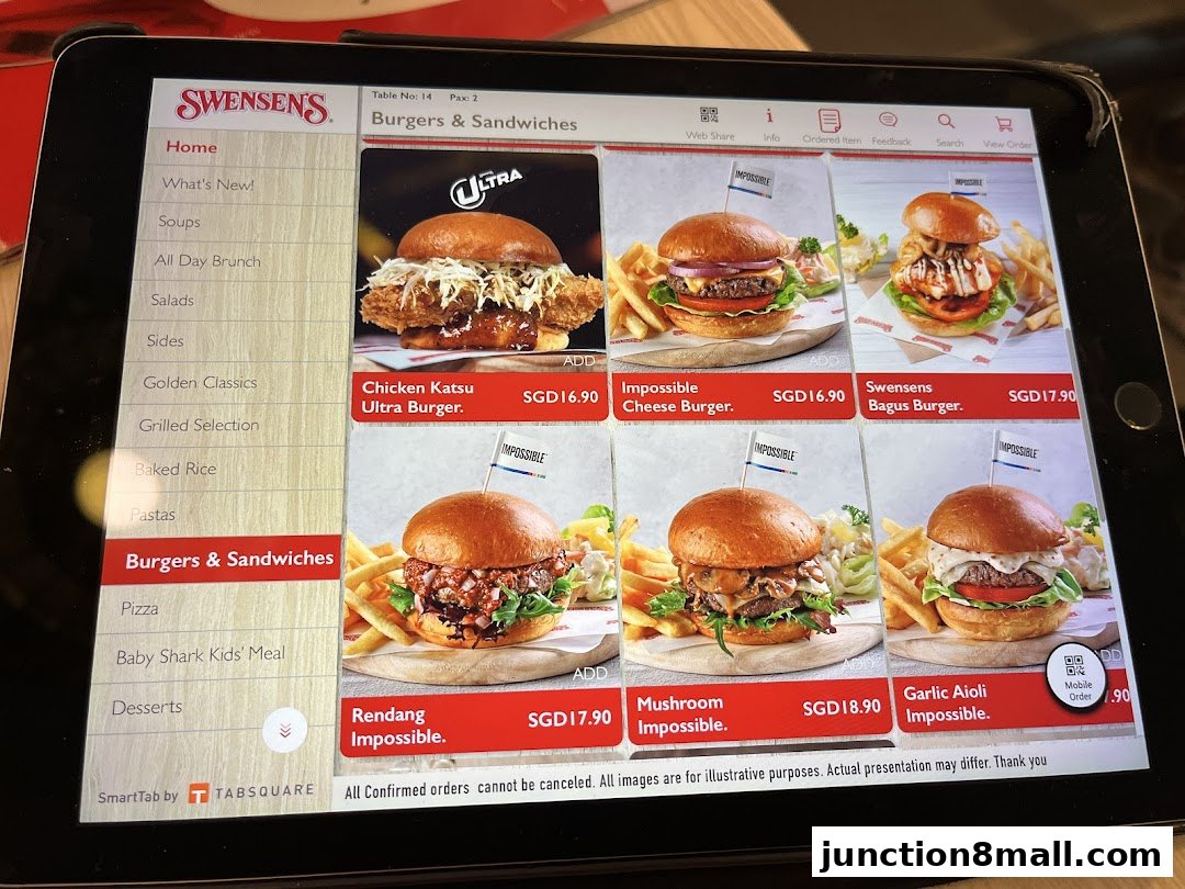 A tablet screen displaying the Swensens menu with various burgers and sandwiches.
