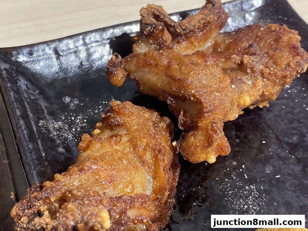 Close-up of crispy, golden-brown Taiwanese fried chicken pieces on a black plate.