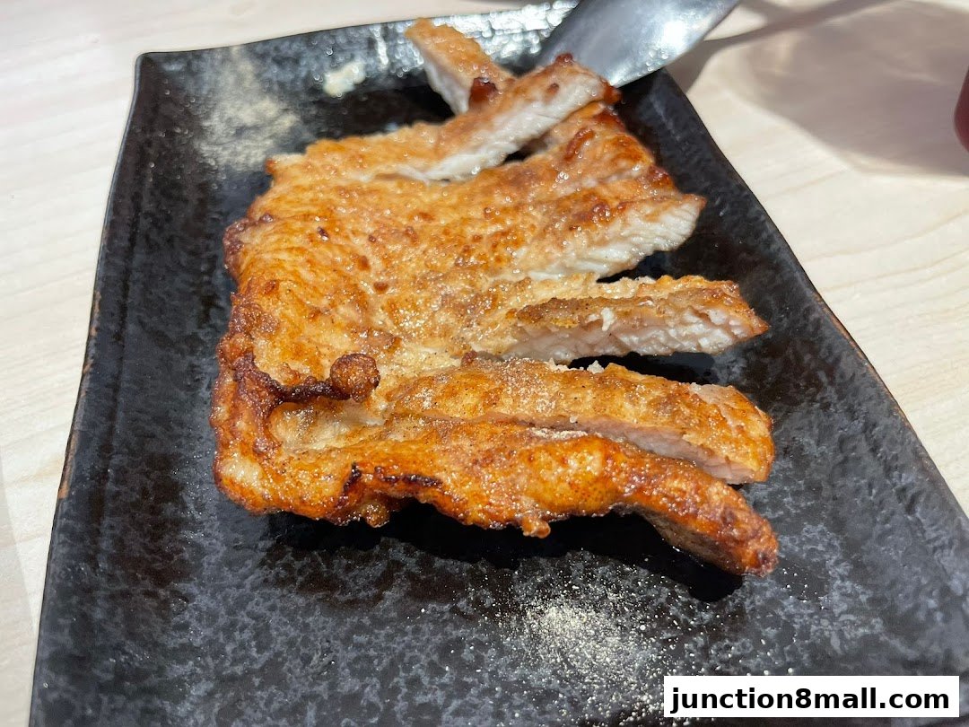 A close-up shot of delicious, crispy fried pork cutlets on a black plate.